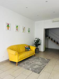 - un canapé jaune dans le salon dans l'établissement A Quattro di Mazze, à Trapani