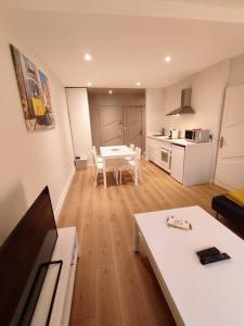 uma sala de estar com uma mesa e uma cozinha em Appartement hyper centre em Lons-le-Saunier