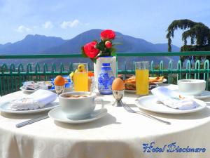 einen Tisch mit einem weißen Tischtuch und einem Tisch mit Kaffee und Blumen in der Unterkunft Hotel Diecimare in Cava deʼ Tirreni