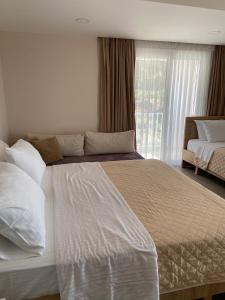 a bedroom with a large white bed and a window at Persephone in Himare