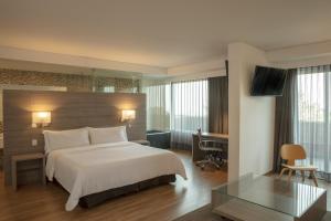 モレリアにあるFiesta Inn Morelia Altozanoのベッドとガラスのテーブルがあるホテルの部屋 +27枚の写真