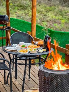 a table with food and a fire on a deck at ME-GA Glamping in Sapanca