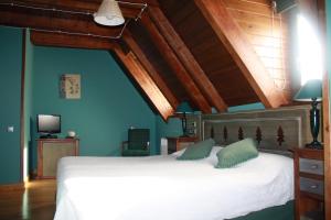 a bedroom with a large white bed with green pillows at Hotel Casa Estampa in Escuñau