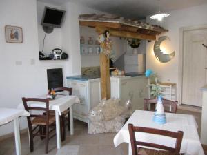 cocina con mesa y sillas y cocina con encimera en Bed & Breakfast Mare Isole, en La Maddalena