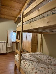 a bedroom with two bunk beds in a cabin at Cal Lluch in Víllec