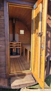 an open door of a wooden cabin with a stove at Ferienhaus 55 im Seepark Kirchheim in Kirchheim