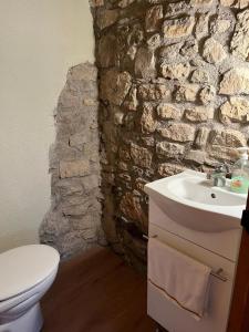 a bathroom with a sink and a stone wall at Cal Lluch in Víllec