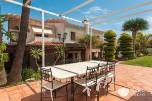 une table et des chaises devant une maison dans l'établissement Sky Sea Holidays VILLA MONTILLA, à Alhaurín de la Torre