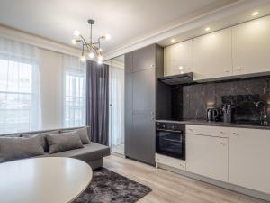 a kitchen with a couch and a table in a room at Enes Apartments Softy Lofty 2 in Wrocław