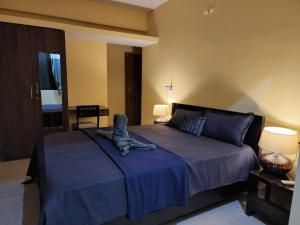 um quarto com uma cama grande e um cobertor azul em SD D'Souza Heritage Moira Flats with Reserved Parking em Moira