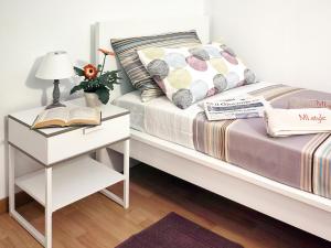 una camera con un letto con comodino e un libro di MI. Style a Milano