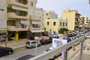 a busy city street with cars parked in front of buildings at Pasiphae Heraklion Apartment in Heraklio Town