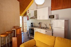 a kitchen with a yellow couch in a kitchen at 2 bedrooms appartement at Vilanova 100 m away from the beach with sea view enclosed garden and wifi in Aldán