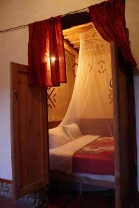 a bedroom with a bunk bed with a canopy at Riad Les 5 Lunes in Aït Idaïr