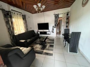 - un salon avec un canapé et une télévision dans l'établissement TrierHouse, à Douala