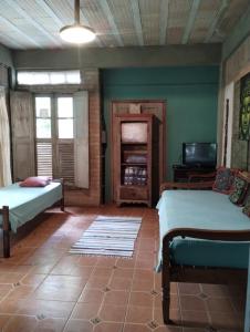 a room with two beds and a tv in it at Aldea Zen Chales Privativos in Ouro Preto