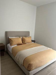 a large bed in a bedroom with a white wall at Departamento Tipo Loft, zona ajijic. in Jocotepec