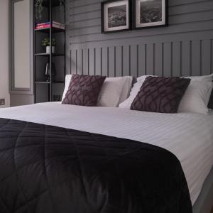 uma cama grande com duas almofadas em cima em NE1 Luxury City Centre Apartment em Newcastle upon Tyne