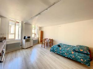 1 dormitorio con 1 cama y cocina con mesa en Gorges du Verdon - Hyper centre Castellane - Rue Piétonne - Studio 3 Couchages, en Castellane