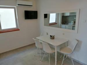 a white table and chairs in a room with a mirror at Apartmani More in Petrovac na Moru