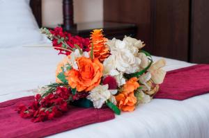 a bouquet of flowers sitting on top of a bed at فندق دار الريس - Dar Raies Hotel in Mecca