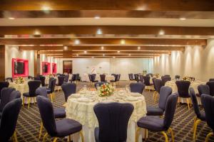 a ballroom with tables and chairs and a room filled with at Gamma Merida El Castellano in Mérida
