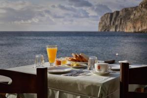 una mesa con un plato de comida y vistas al océano en Akroyiali - Guesthouse, en Yerolimin