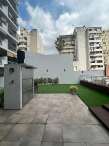 un patio trasero con una pared blanca y un césped en Apartment in Downtown Buenos Aires en Buenos Aires