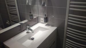 a bathroom with a white sink and a mirror at Hôtel Carpe Diem in Savigneux