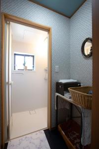 baño con puerta blanca y lavamanos en An old house with a fire pit for rent Guesthouse Yukarian - Vacation STAY 87627v 