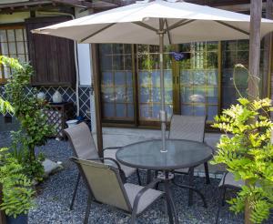una mesa y sillas bajo una sombrilla en un patio en An old house with a fire pit for rent Guesthouse Yukarian - Vacation STAY 87627v, 