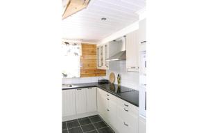 a kitchen with white cabinets and a black counter top at Beautiful Home In Svsj With 3 Bedrooms And Wifi in Gistingstorp
