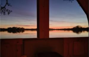 a window view of a lake at sunset at 3 Bedroom Awesome Home In Sävsjö in Gistingstorp