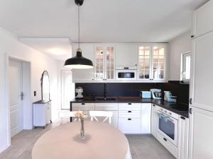 a kitchen with white cabinets and a table at Leut in Nečujam