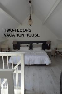 een slaapkamer met een bed en een vakantiehuis met 2 verdiepingen bij Huis aan Honte in Dishoek