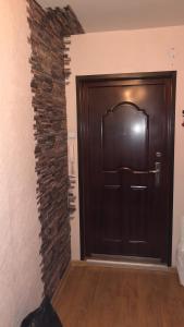 una porta nera in una stanza con un muro di mattoni di Maleva apartaments a Kohtla-Järve