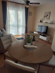 uma sala de estar com uma mesa e um sofá em Apartman Lucy em Baošići