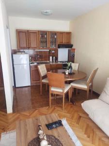 a living room with a table and a kitchen at Apartman Lucy in Baošići