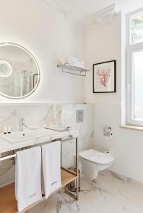 a white bathroom with a sink and a toilet at Villa Antonina in Sopot