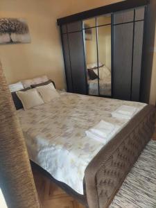 sypialnia z dużym łóżkiem z lustrem w obiekcie Apartman Lucy w mieście Baošići