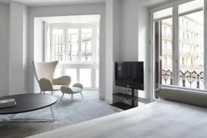 sala de estar con TV, sofá y sillas en Easo Suite 7 by FeelFree Rentals, en San Sebastián