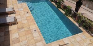 an overhead view of a swimming pool with blue water at Casa Vermelha in Pipa