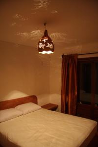 a bedroom with a bed and a light hanging from the ceiling at Casa Vermelha in Pipa