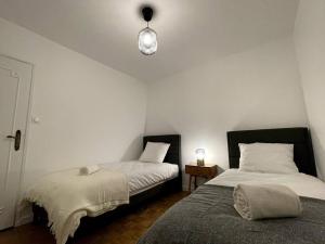 a bedroom with two beds and a lamp on the wall at Love Games in Plérin