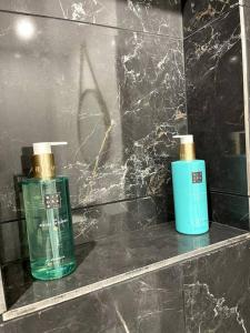 two bottles ofodorizers sitting on a shelf in a bathroom at Love Games in Plérin