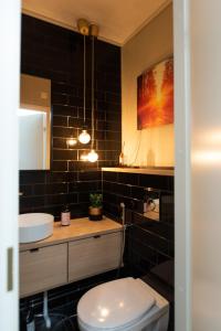 a bathroom with a toilet and a sink and a mirror at Tyylikäs City-huoneisto in Tampere