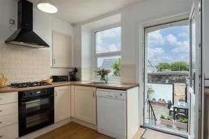 a kitchen with a stove top oven next to a window at Lavender Terrace in Llandudno