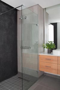 La salle de bains est pourvue d'une douche en verre et d'un lavabo. dans l'établissement Neighbourgood Old Cape Quarter, au Cap