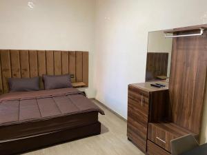 een slaapkamer met een bed, een dressoir en een spiegel bij Hôtel Meuble Parisien in Rabat