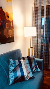 un divano blu in soggiorno con lampada di Appartamento tra Aeroporto DaVinci e Fiera di Roma a Fiumicino